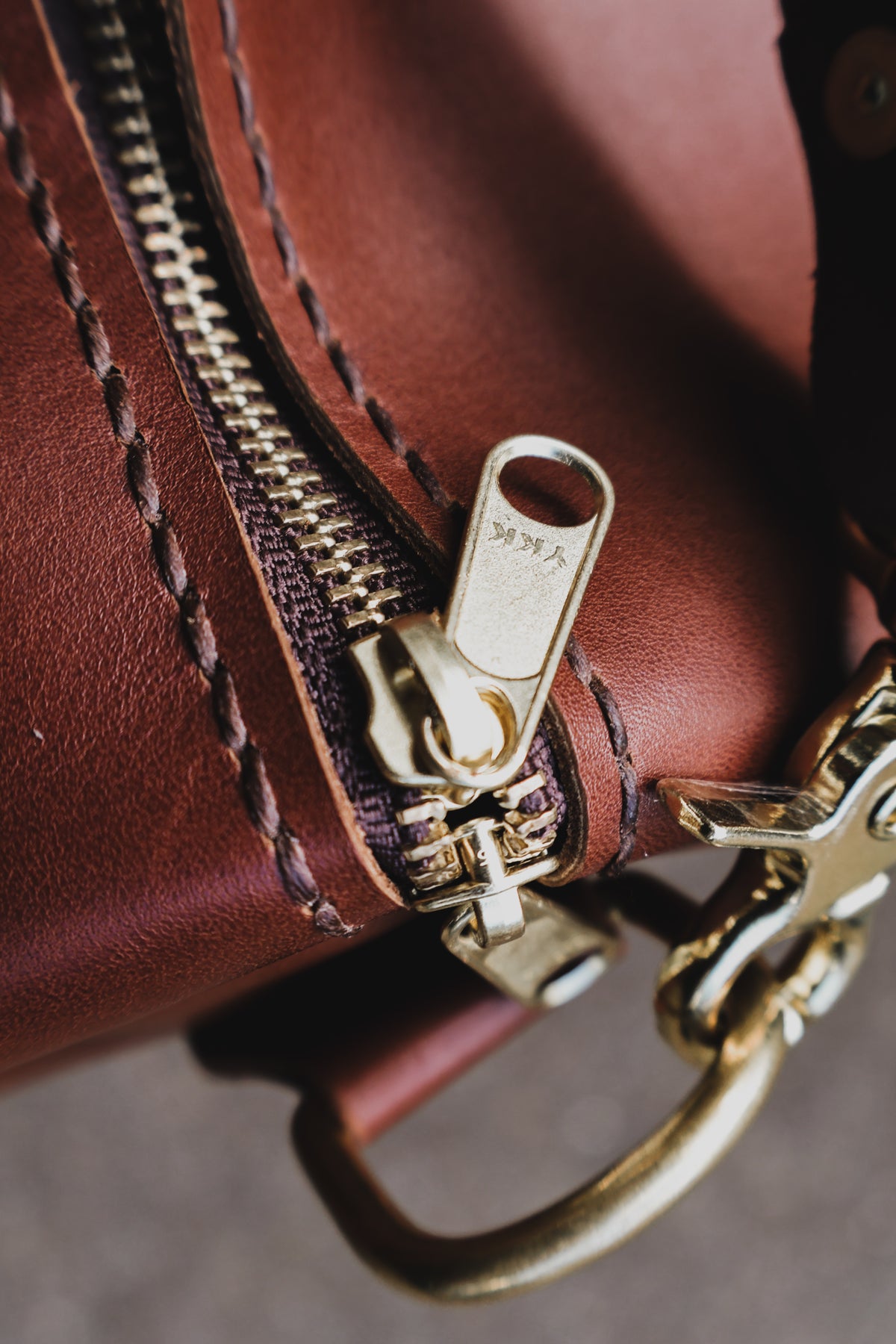 Close-up of The Bully Duffel Bag’s YKK brass zipper, leather stitching and solid-brass shoulder-strap clasp.