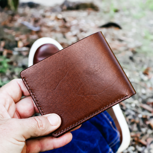 Chestnut Italian Buttero leather bi-fold wallet held outdoors, made by MANEO Leather in Queensland.