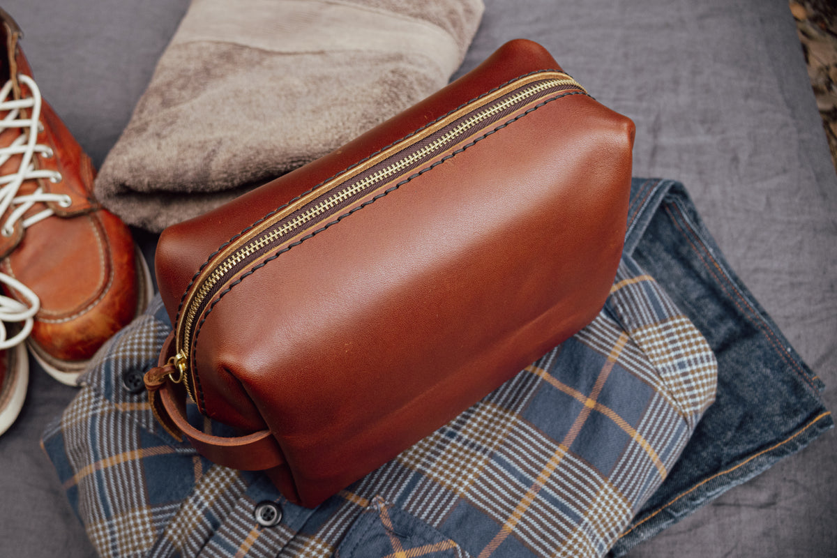 Brown full-grain leather Buddy toiletry bag with brass zipper and vegetable-tanned handle, made by MANEO Leather.